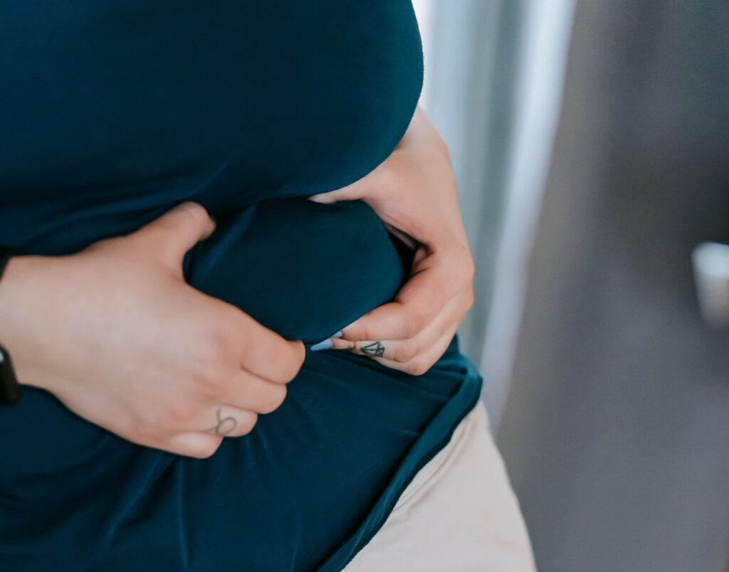 Person holding their stomach in discomfort, illustrating common signs of gut-brain imbalance