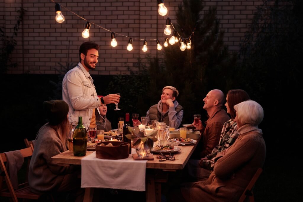 Multi-generational family enjoying dinner together outdoors, representing strong relationships that support longevity