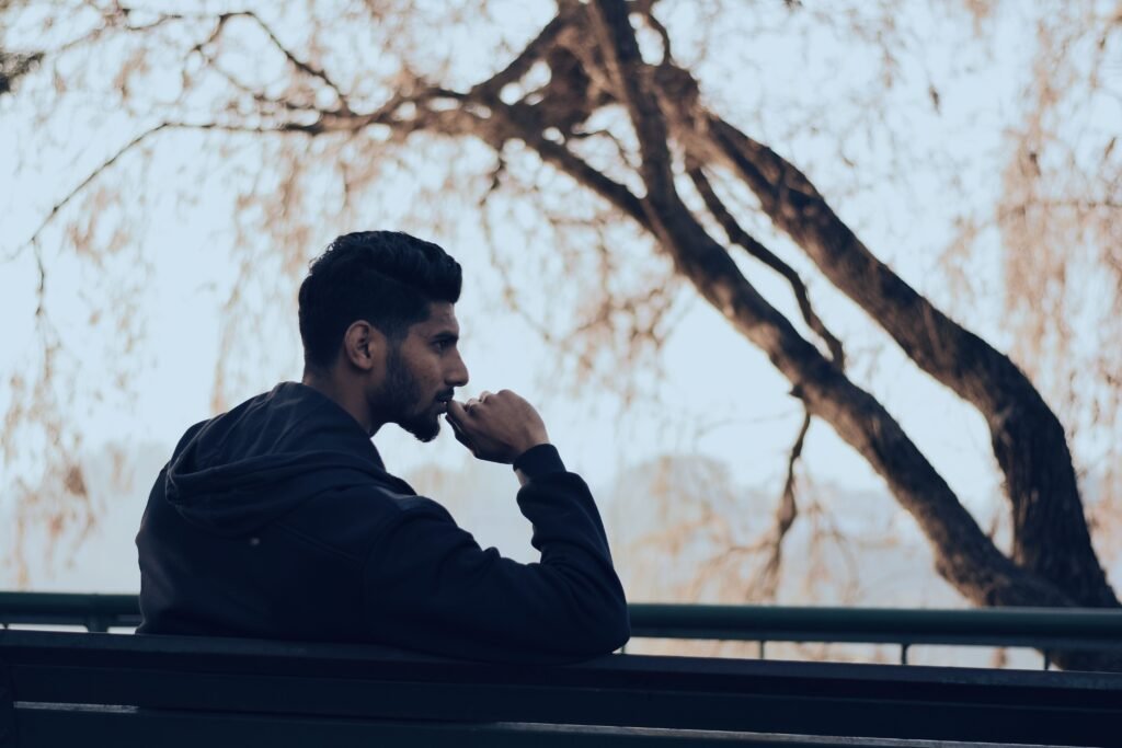 Man sitting thoughtfully outdoors, representing the reflective mindset behind long-term health decisions