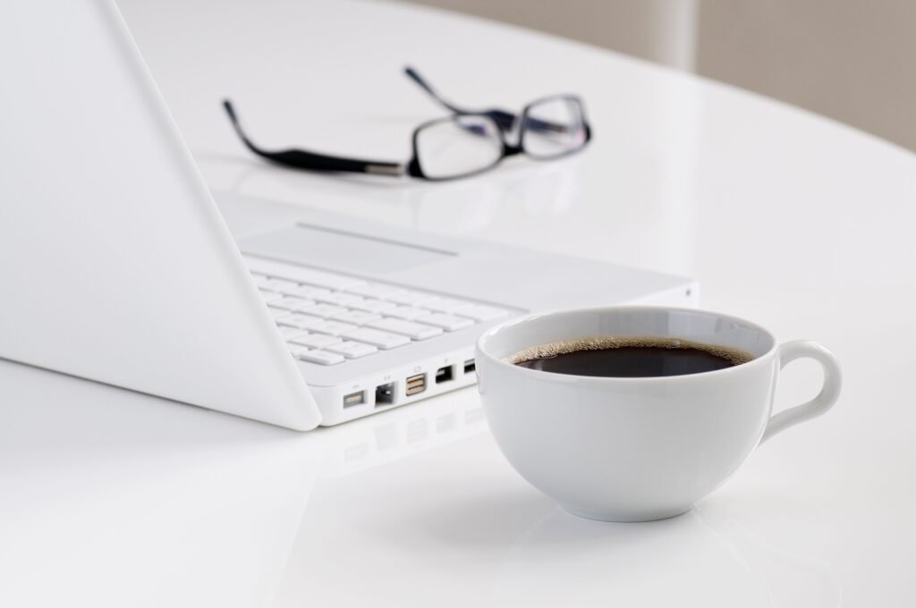 Coffee break beside laptop showing importance of strategic breaks in time management