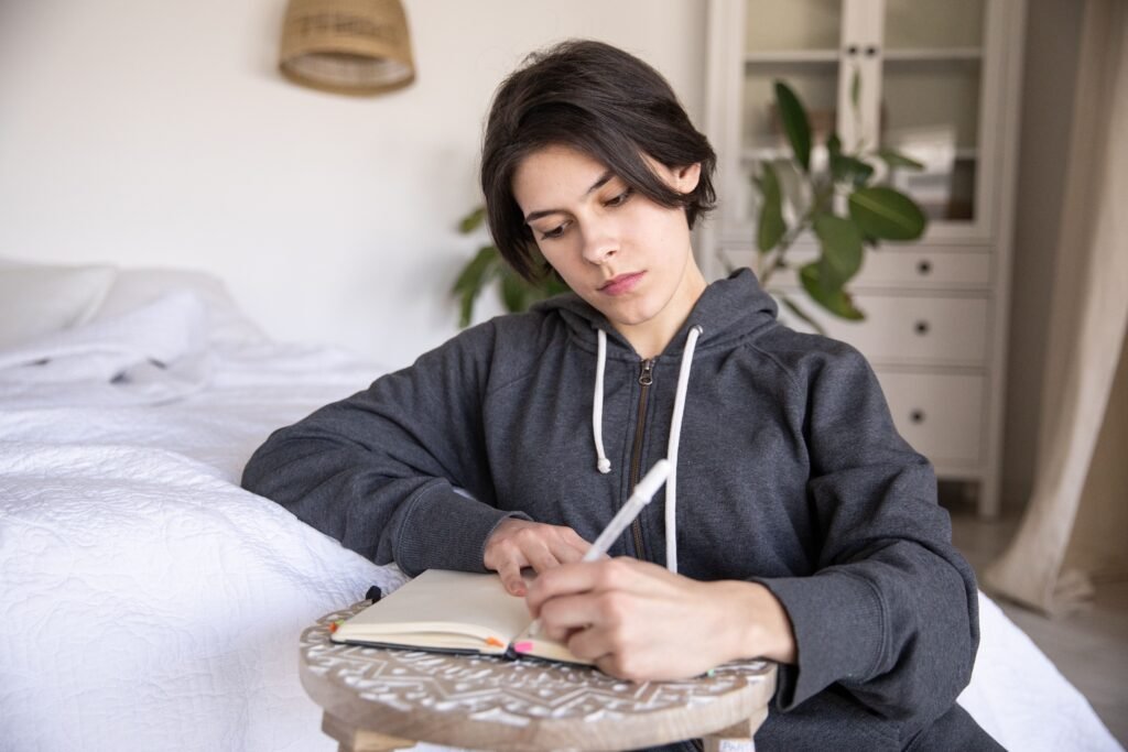 Woman thoughtfully journaling at home, representing the mental shift needed for a longevity mindset