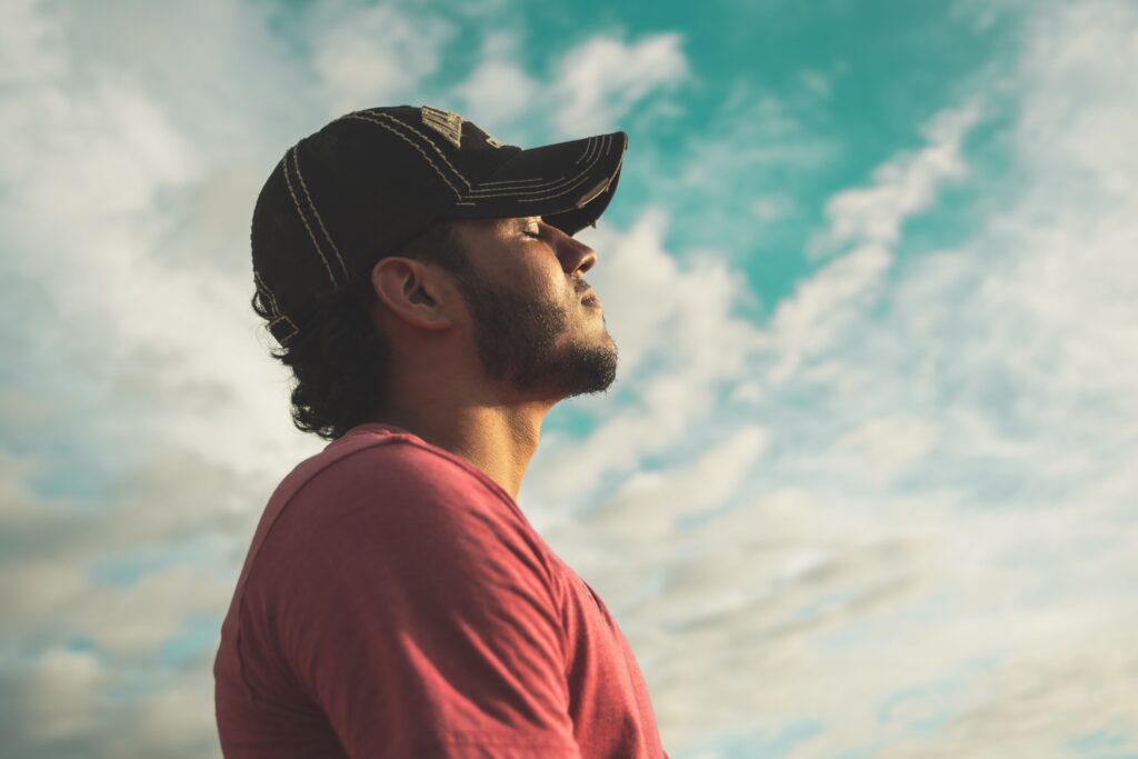 Man taking a calming pause with eyes closed, practicing a moment of non-reactive communication