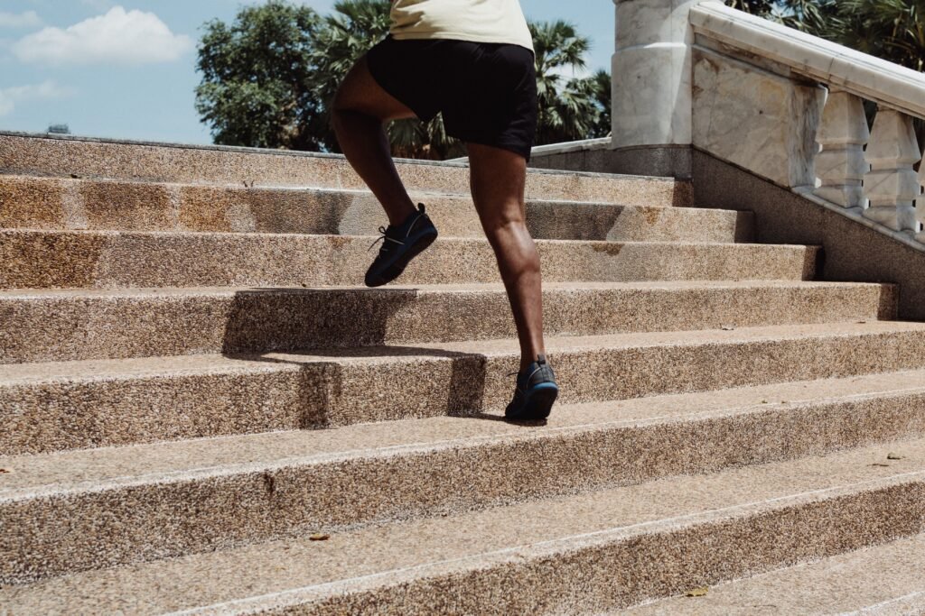 Person climbing stairs one step at a time, symbolizing progress over perfection in goal setting