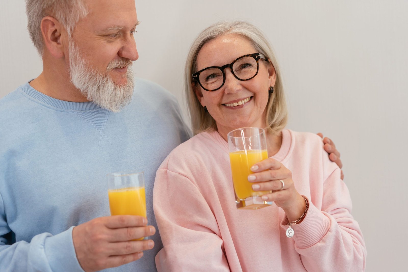 Smiling senior couple enjoying orange juice together, representing the longevity mindset and healthy aging
