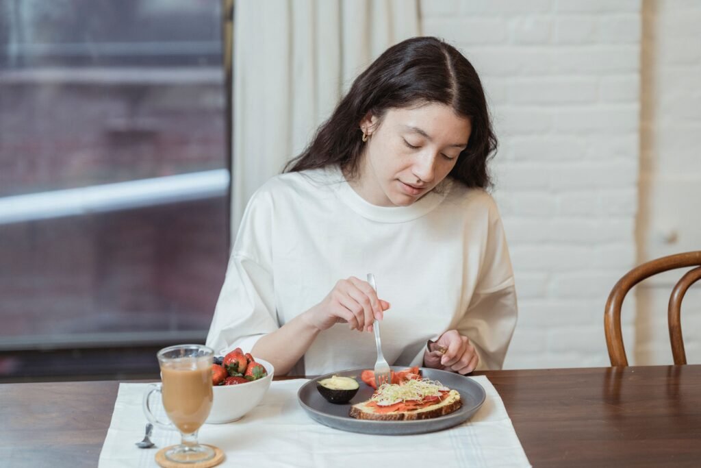 Woman mindfully eating a healthy meal, illustrating the benefits of chewing slowly for better digestion