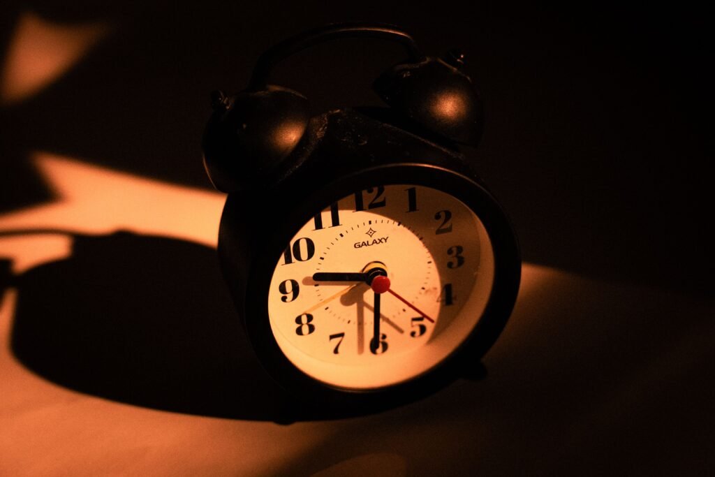 Vintage alarm clock glowing in warm light, representing the importance of anchoring a consistent wake-up time