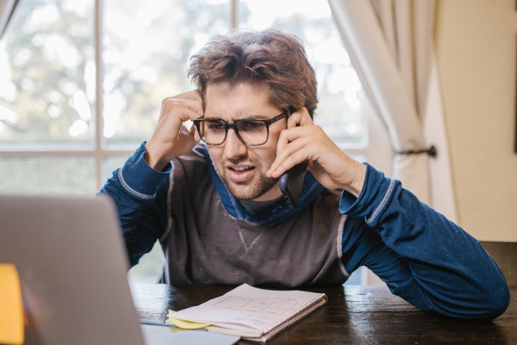 Man showing signs of communication problems while on a confusing phone call