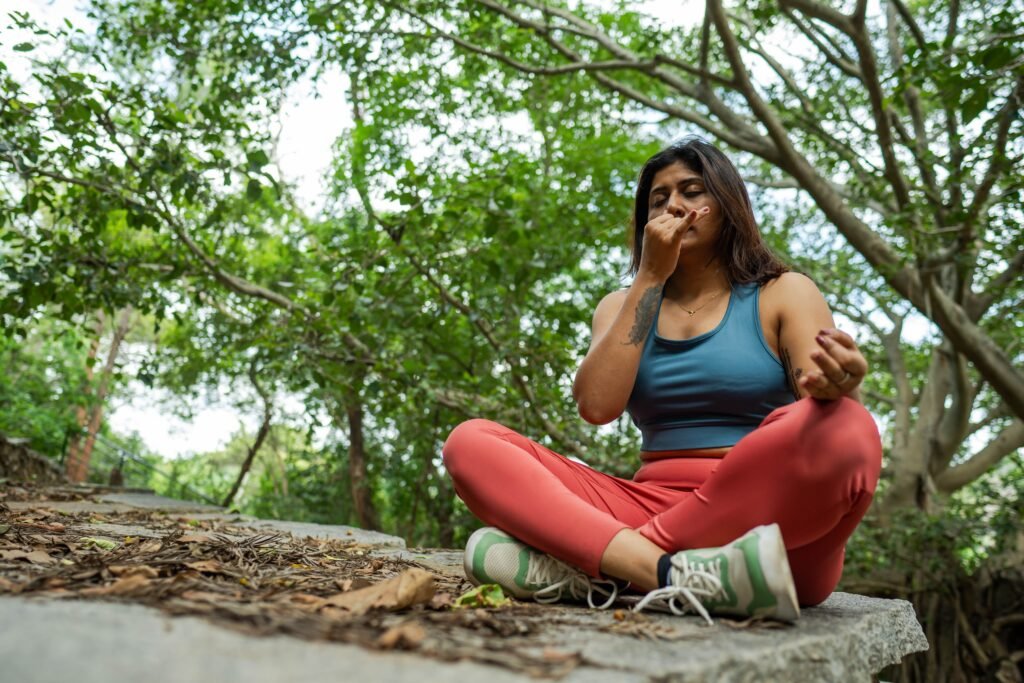 Woman practicing controlled breathing outdoors, illustrating slow exhales as a nervous system regulation technique