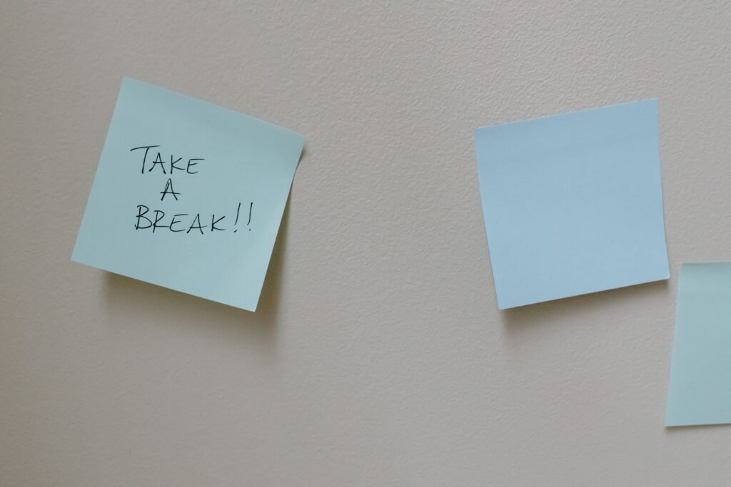 Sticky note reading "Take a Break" on a wall, representing how visible cues help build micro habits