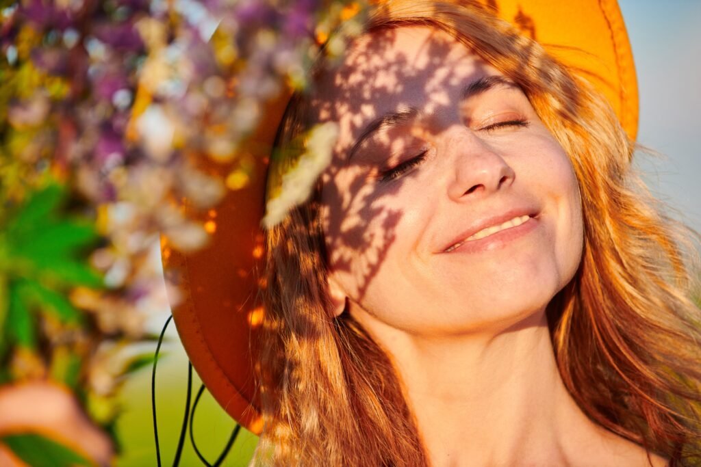 Woman smiling joyfully in warm sunlight, representing the emotional benefits of good gut health