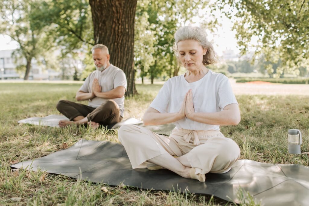 People meditating peacefully outdoors, representing the cultural shift from hustle culture to nervous system regulation
