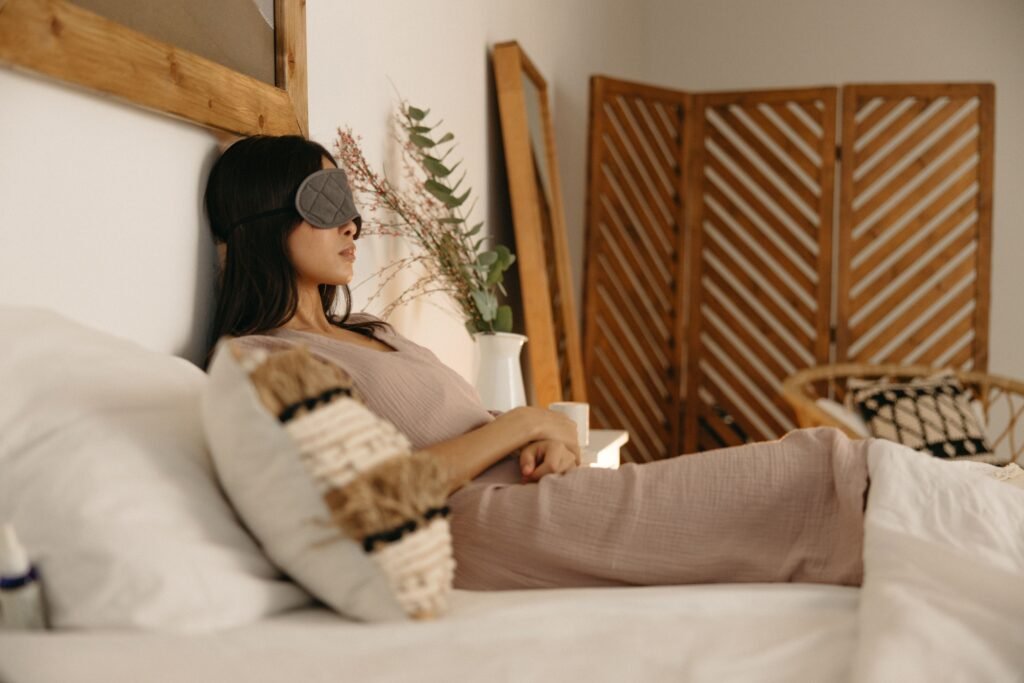 Woman relaxing calmly with an eye mask, illustrating how to let sleep come naturally instead of forcing it