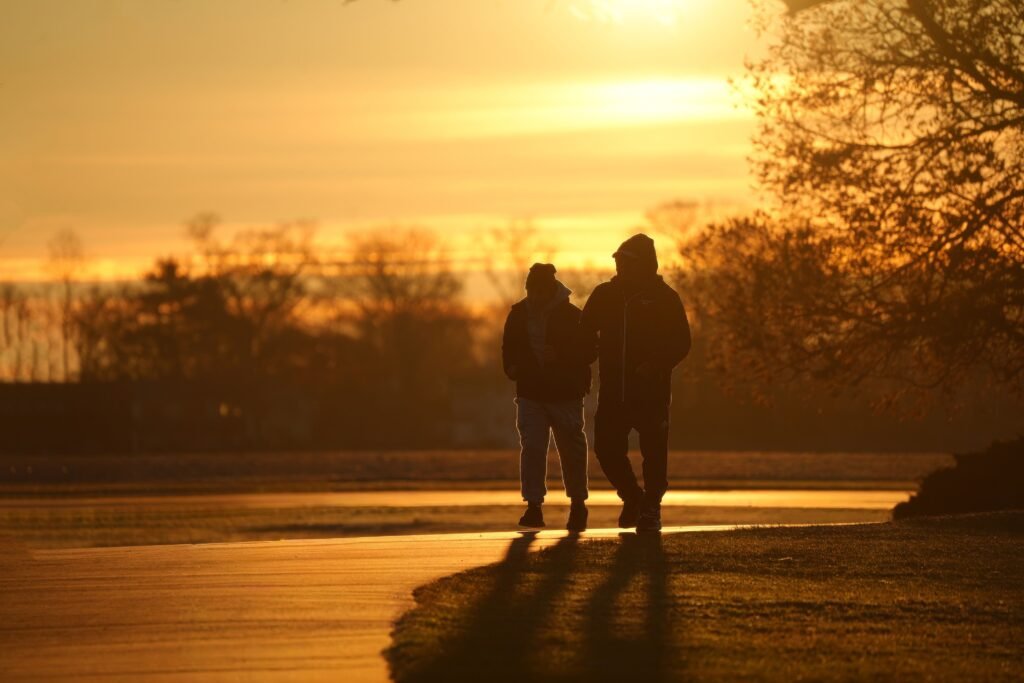 Two people walking outdoors during golden morning sunrise light