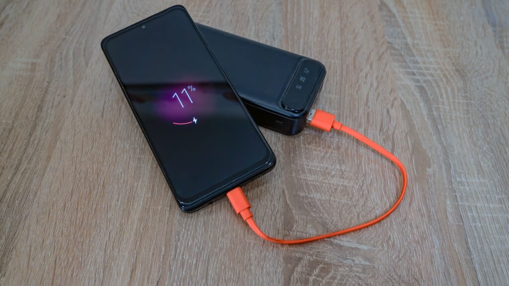 Phone charging on a table away from the bed, illustrating the practical tip of charging your phone outside the bedroom
