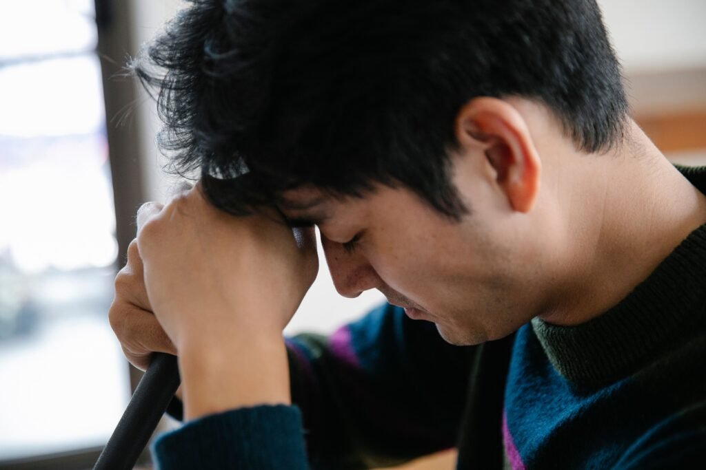 Man resting his head on his hand looking stressed, illustrating how poor sleep affects more than just rest