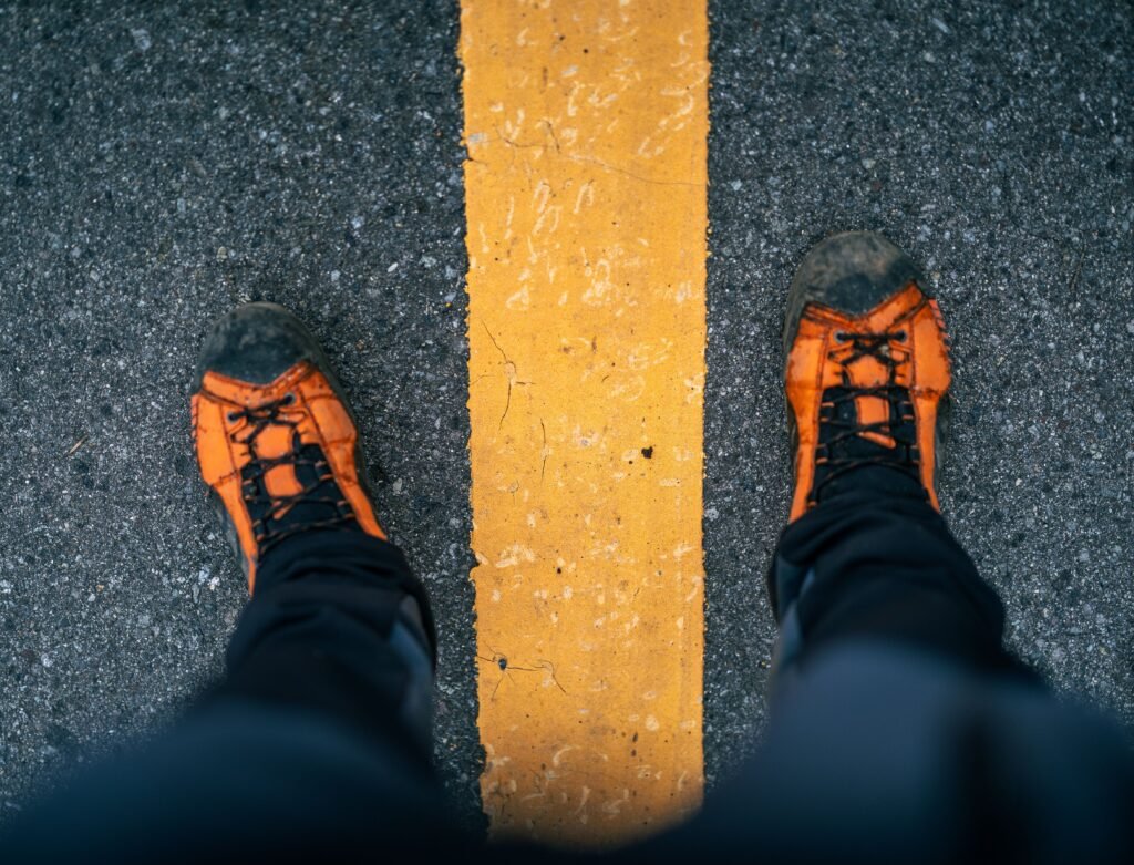 Person standing on a road wearing walking shoes ready to start a walk