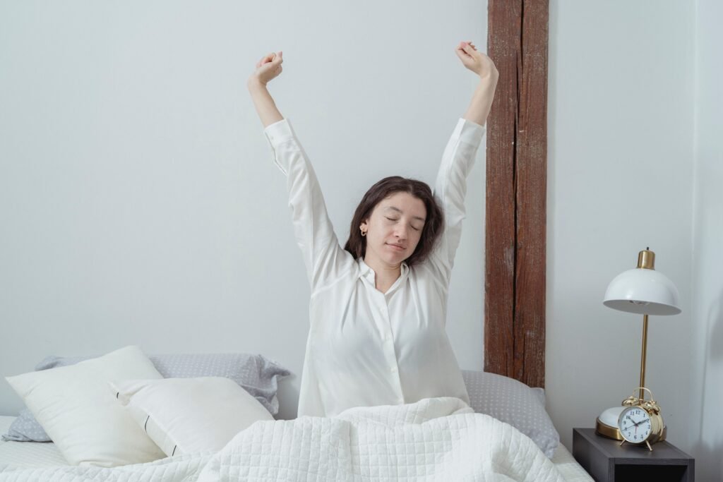 Woman stretching her arms while waking up peacefully in bed