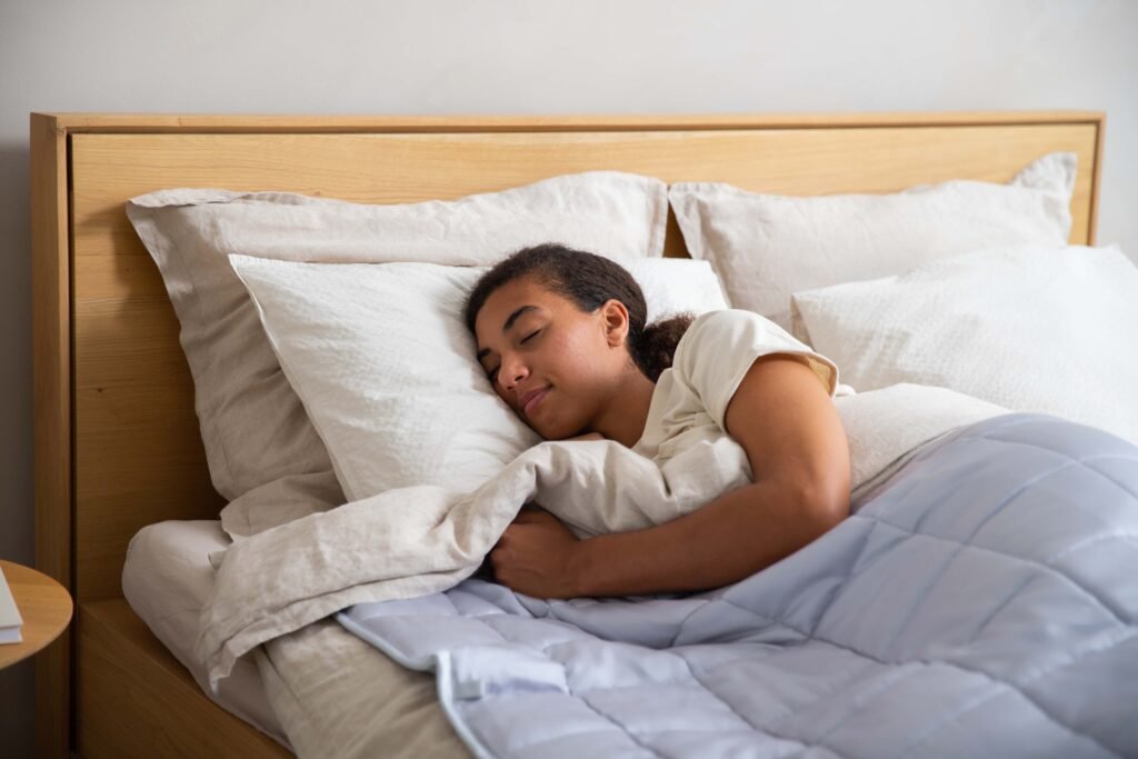 Woman sleeping deeply and peacefully wrapped in blankets, illustrating improved sleep quality after a week without scrolling