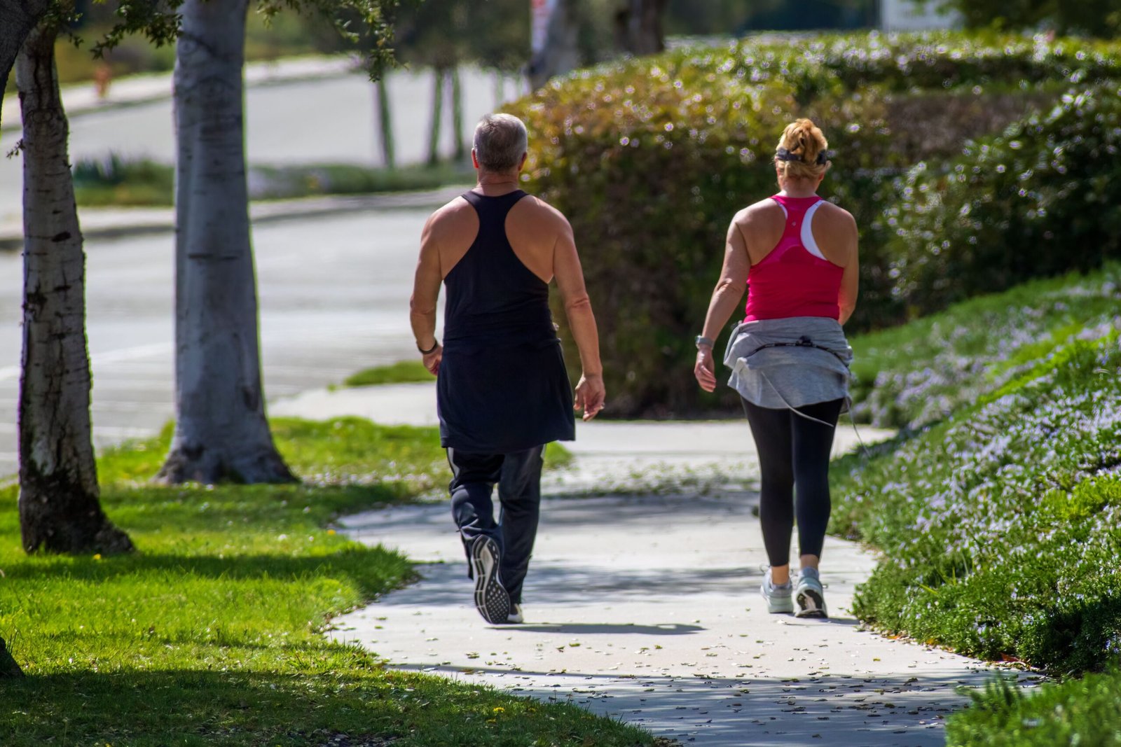 Couple walking together on a neighborhood sidewalk during their morning walk routine