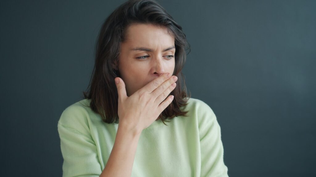 Tired woman yawning showing effects of sleep deprivation on aging